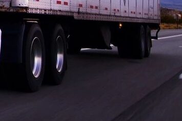 Windham Truck Accident Lawyer presents a photo of a white truck on a highway with blue sky behind